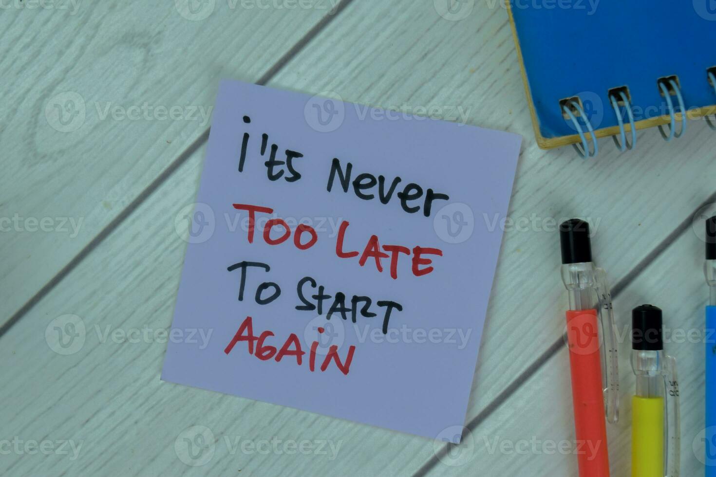 Concept of It's Never Too Late To Start Again write on sticky notes isolated on Wooden Table. photo