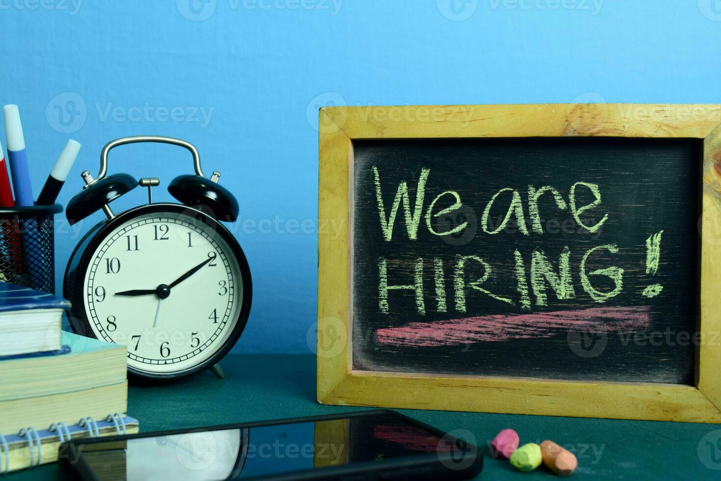 We are Hiring Planning on Background of Working Table with Office Supplies. Business Concept Planning on Blue Background photo