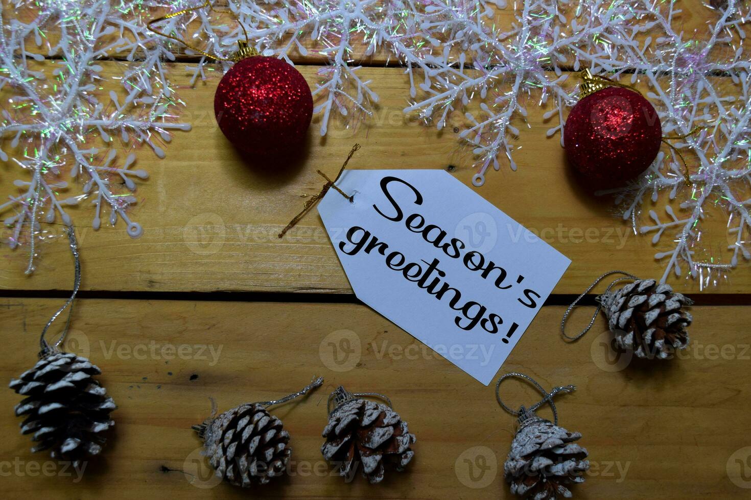 Seasons Greetings write on laber with wooden backgroud. Frame of Christmas Decoration. photo