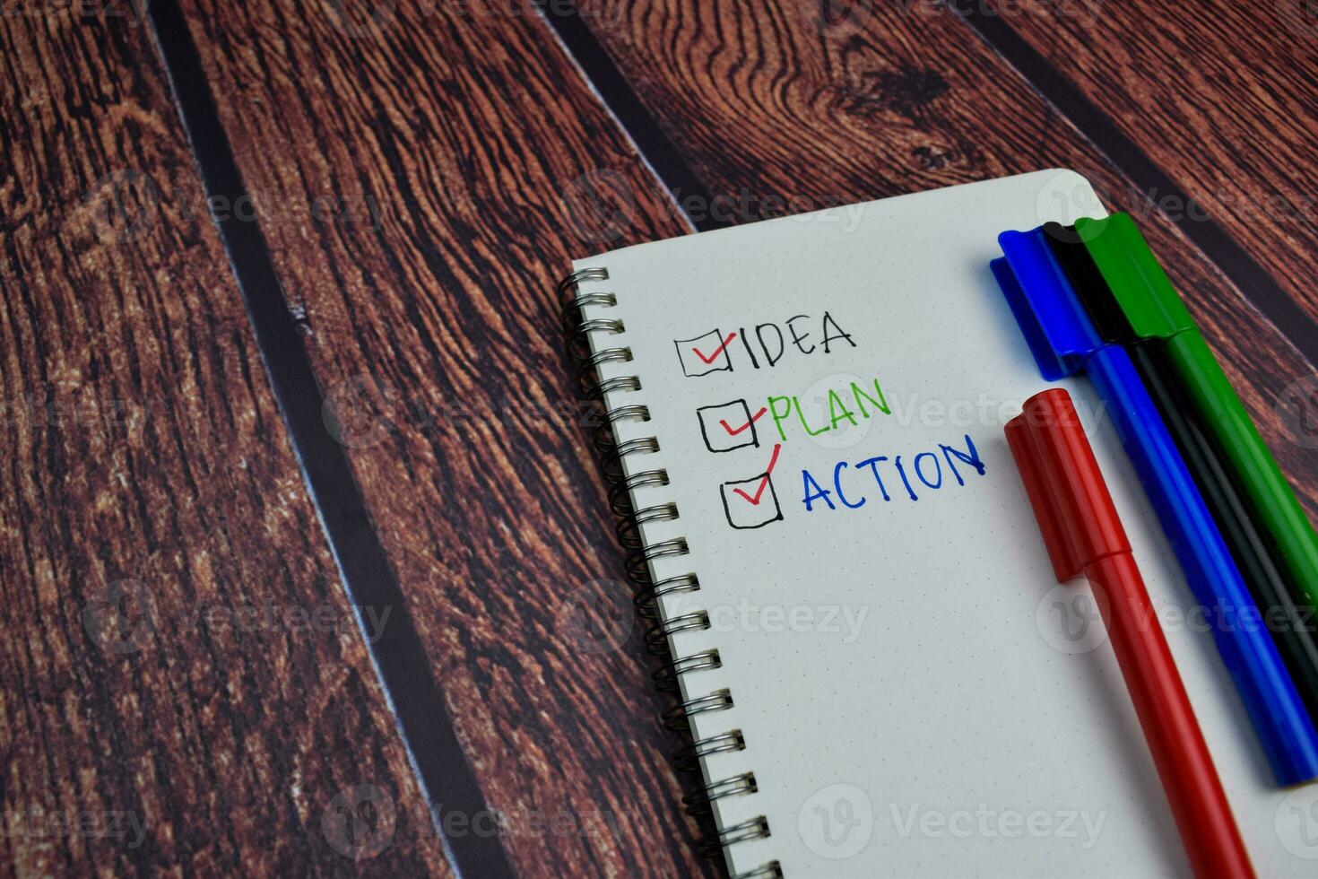 Idea Plan Action write on a book and checklist Isolated on wooden table background photo