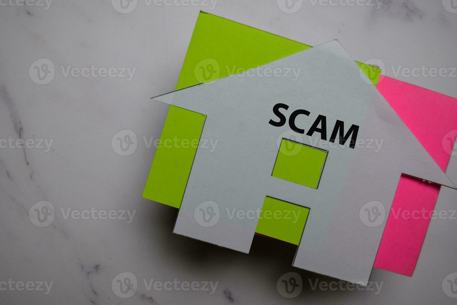 Property Scam write on sticky note and house made from paper isolated on Office Desk. photo