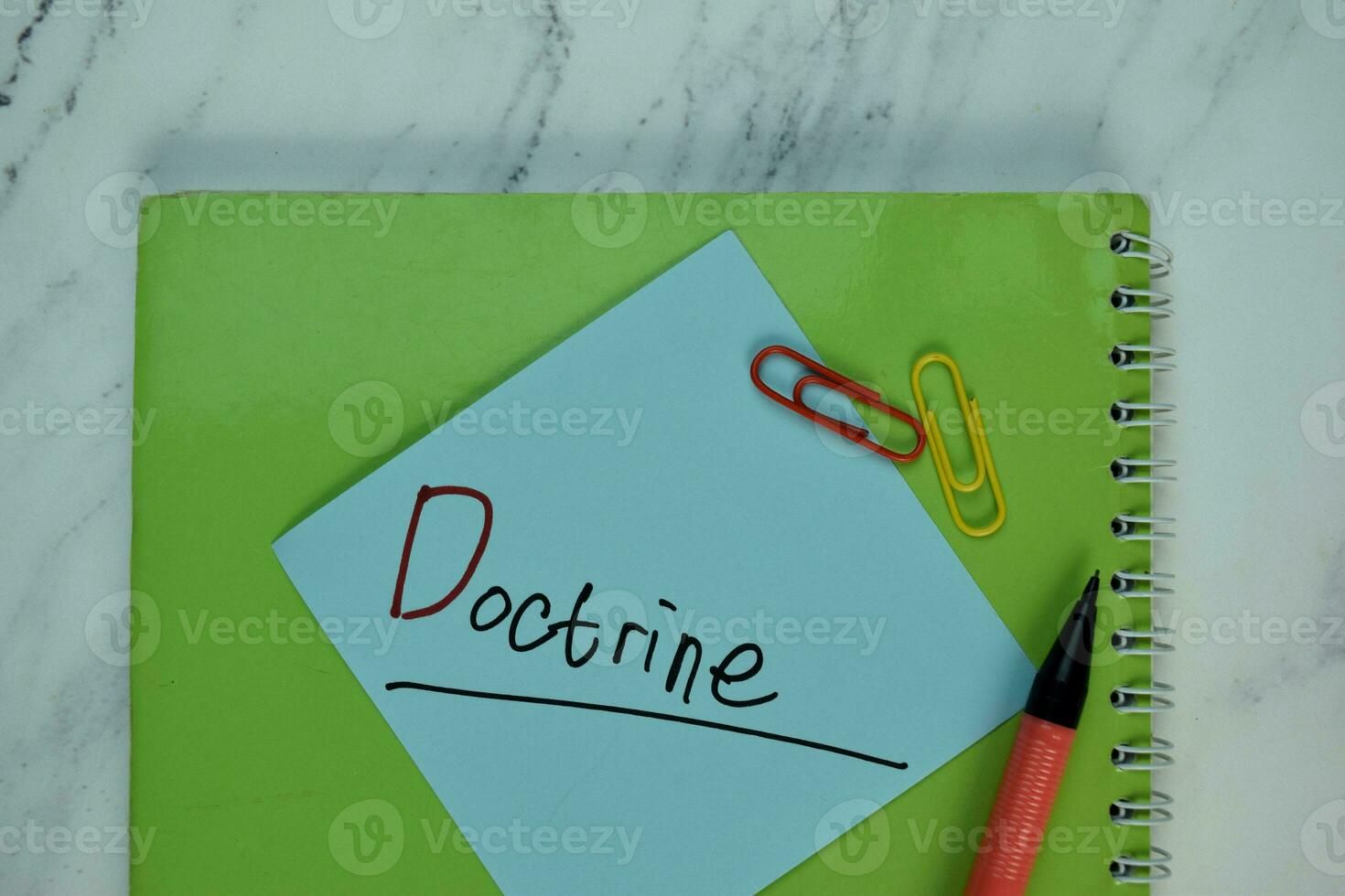 Doctrine write on sticky note isolated on Wooden Table. photo