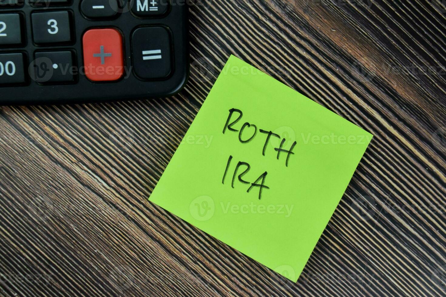 Concept of ROTH IRA write on sticky notes isolated on Wooden Table. photo