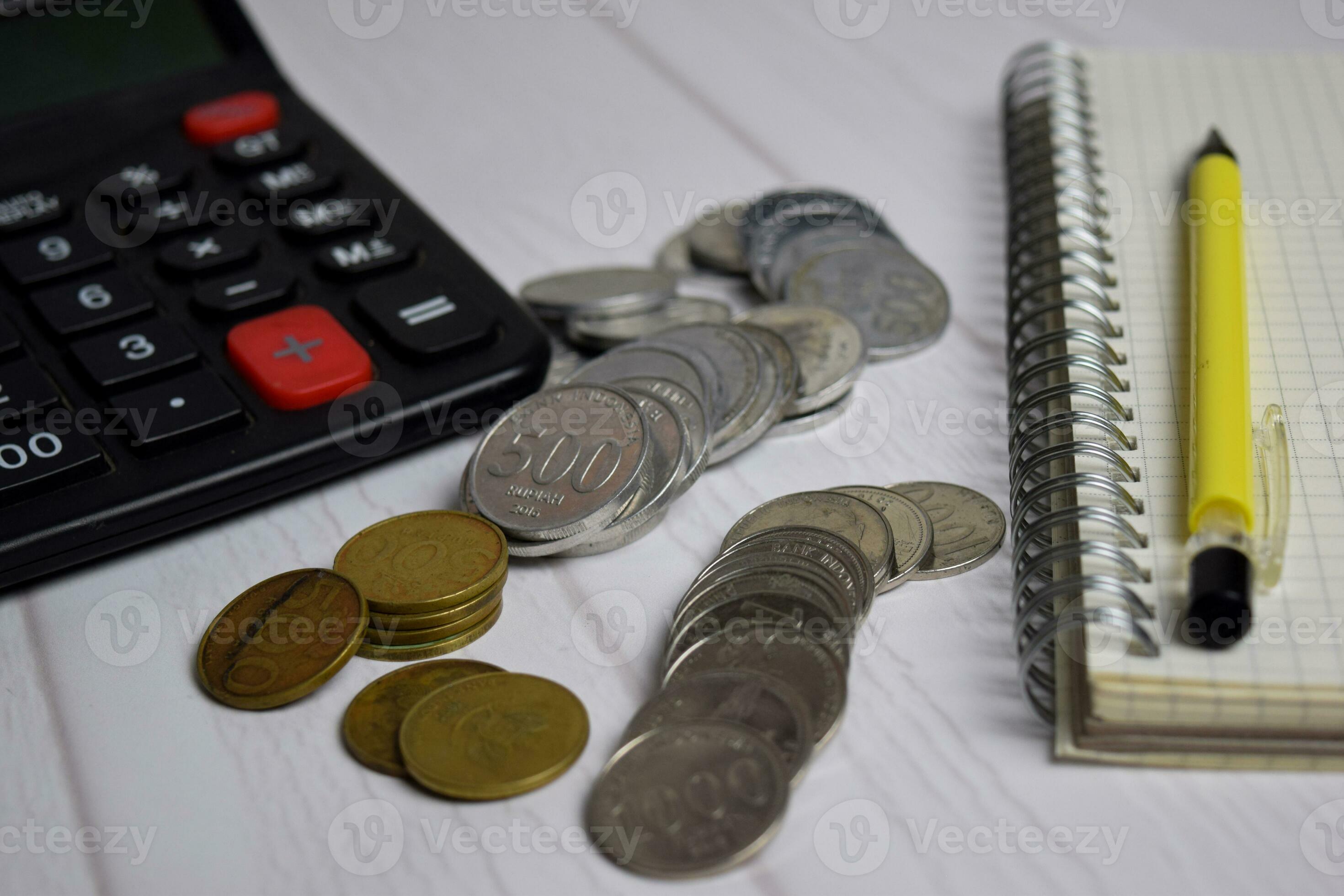 Calculator and the stack of coint isolated on office desk. calculating