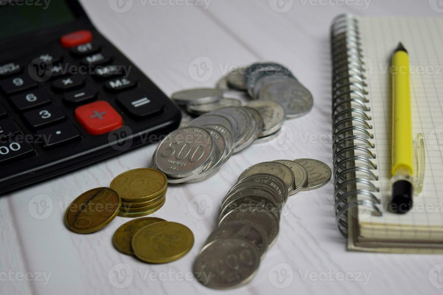 Calculator and the stack of coint isolated on office desk. calculating salary or tax concept photo
