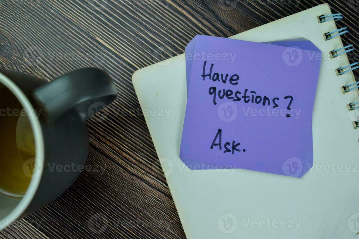 Concept of Have Questions Ask write on sticky notes isolated on Wooden Table. photo