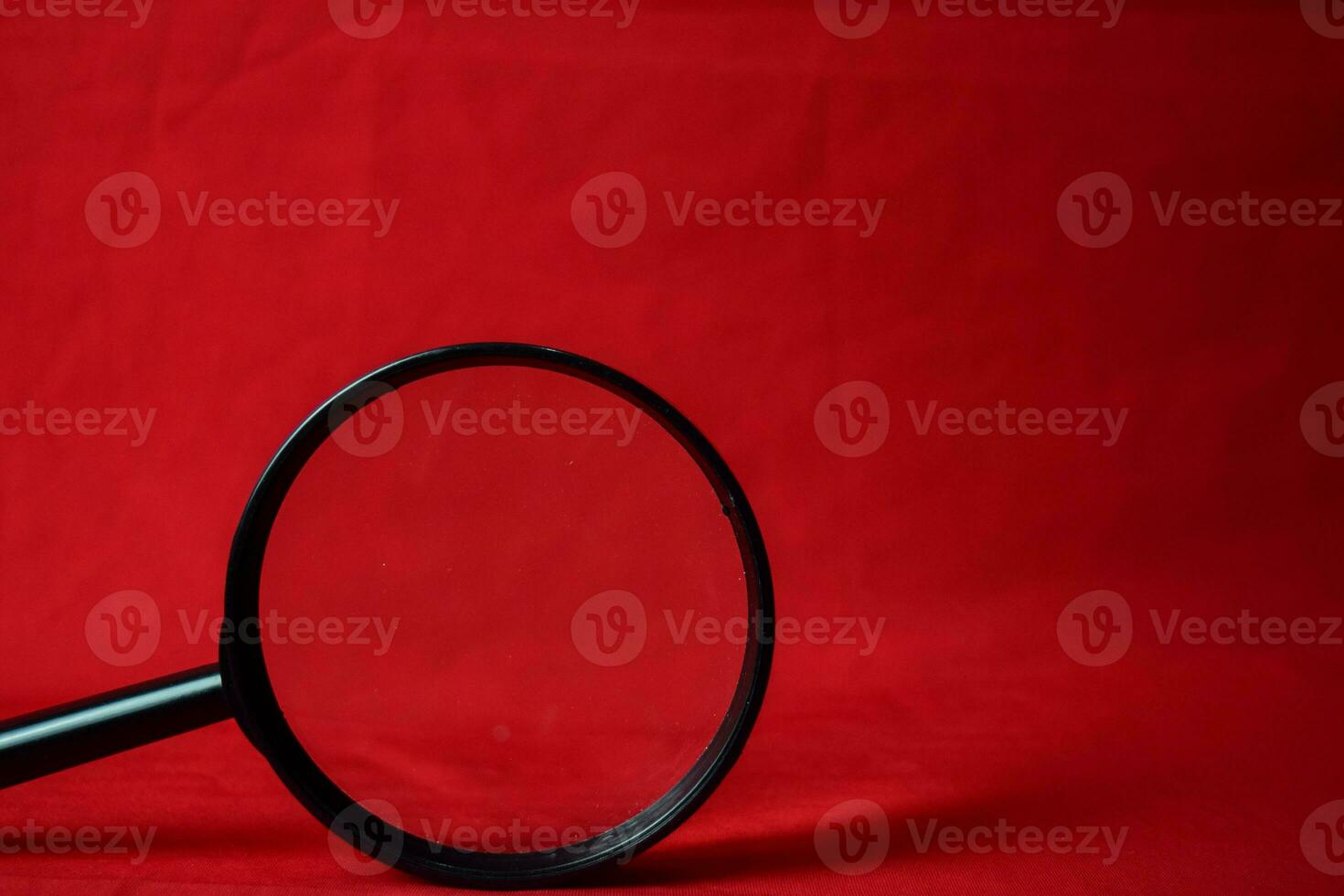 Magnifying glass on red background photo