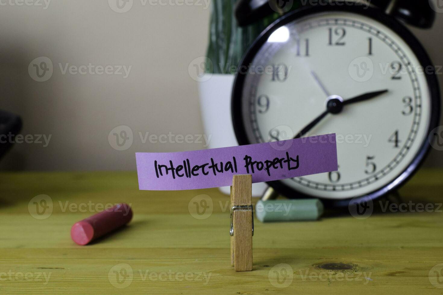Intellectual Property. Handwriting on sticky notes in clothes pegs on wooden office desk photo