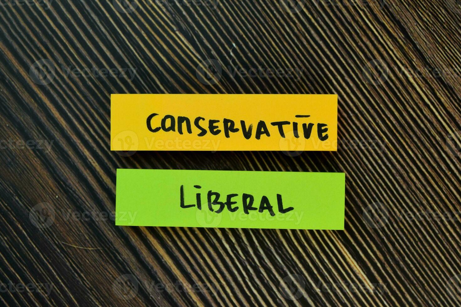 Conservative and Liberal write on sticky notes isolated on Wooden Table. photo