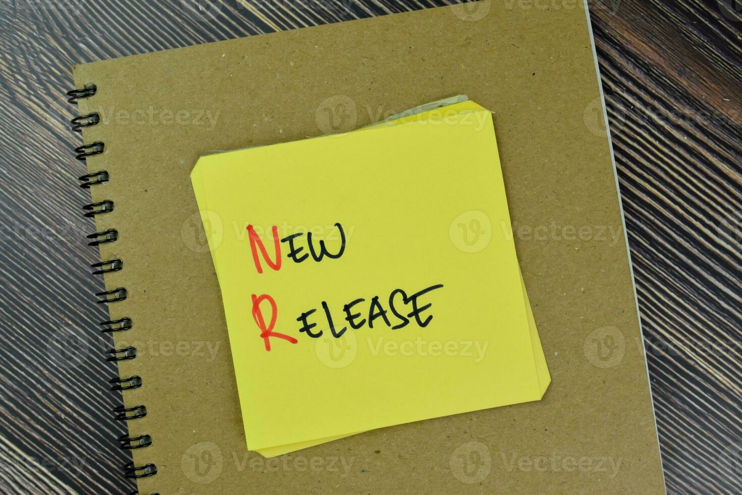 New Release write on sticky notes isolated on Wooden Table. photo