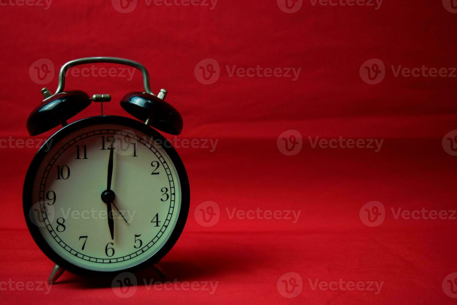 Clock ticking to 6 o'clock on the red background photo