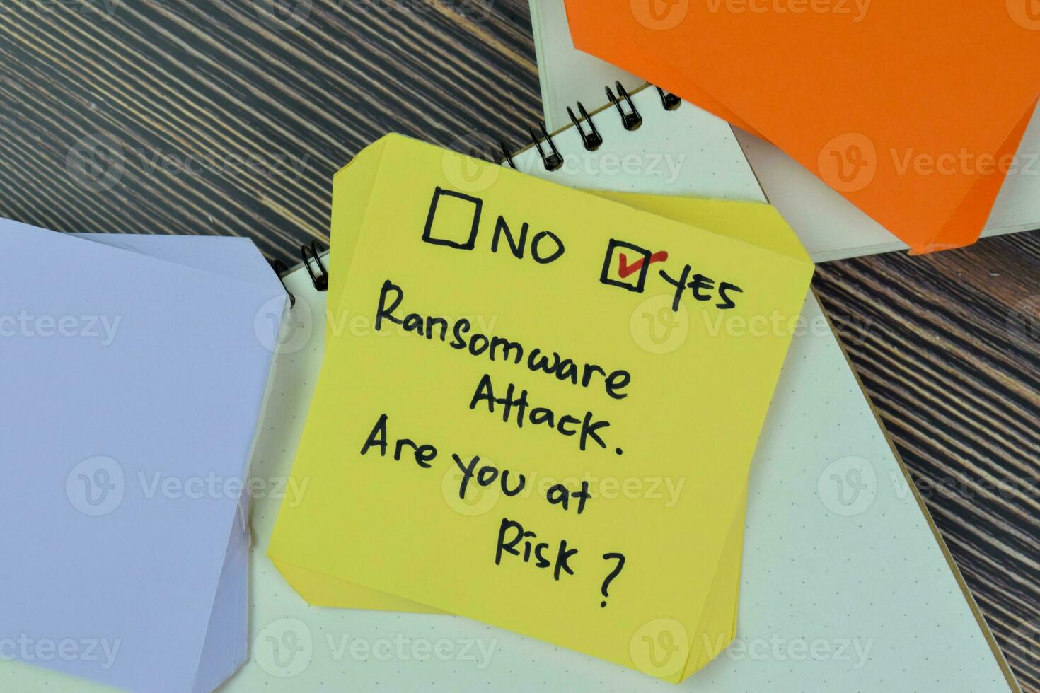 Concept of Ransomware Attack. Are you at risk Yes write on sticky notes isolated on Wooden Table. photo