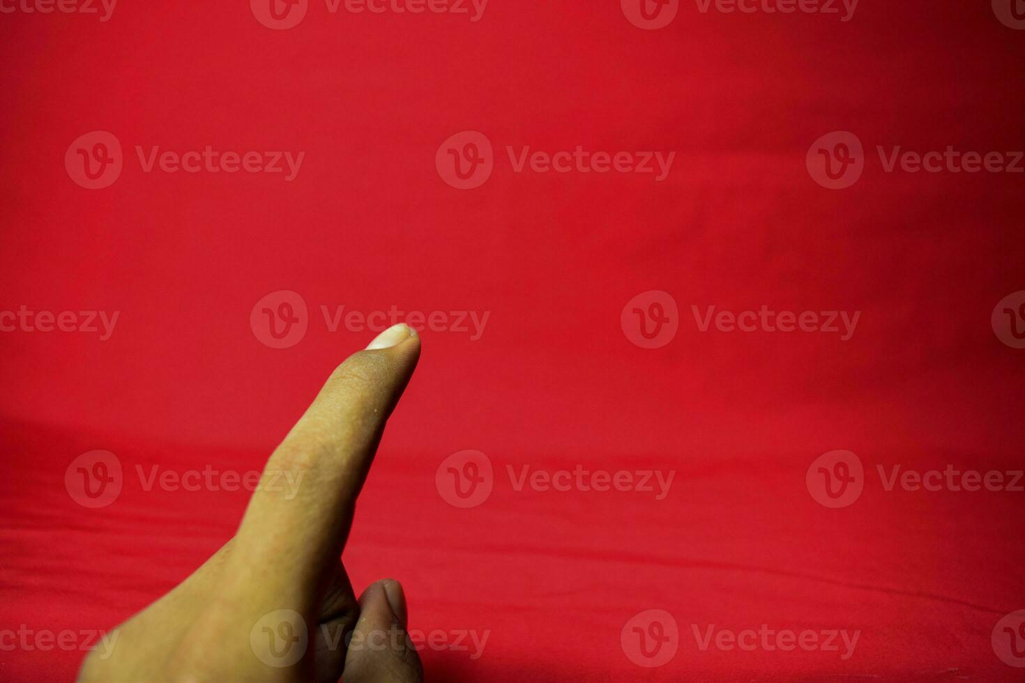 Hand with finger held up on the red background photo