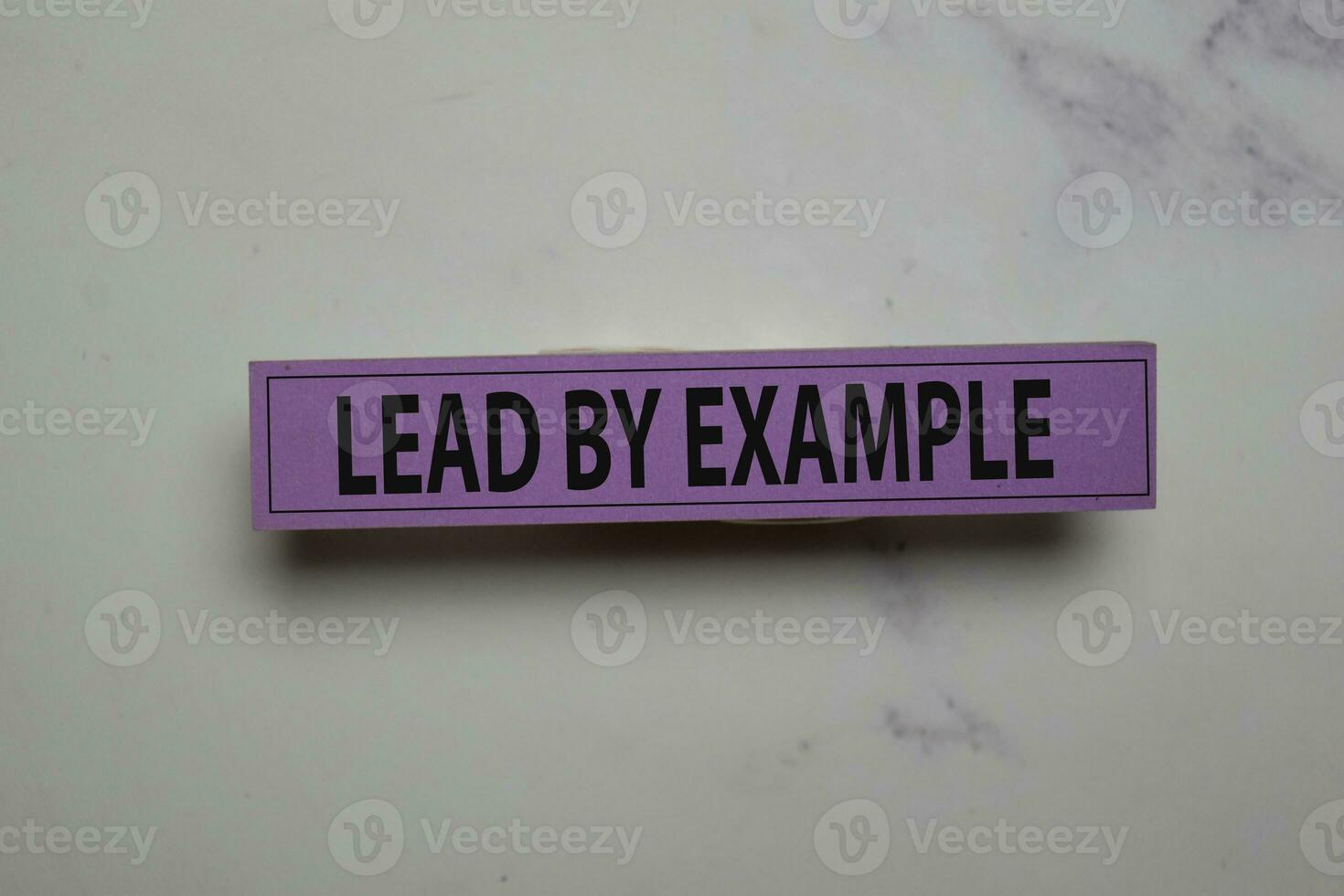 Lead by Example write on sticky note isolated on Office Desk photo