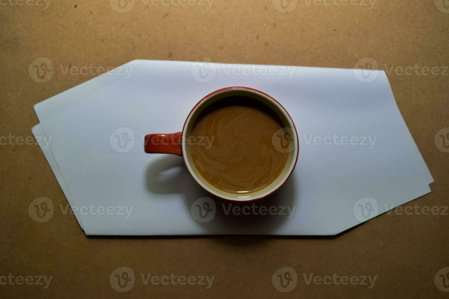 Close up cappuccino in red glass isolated on wooden table photo