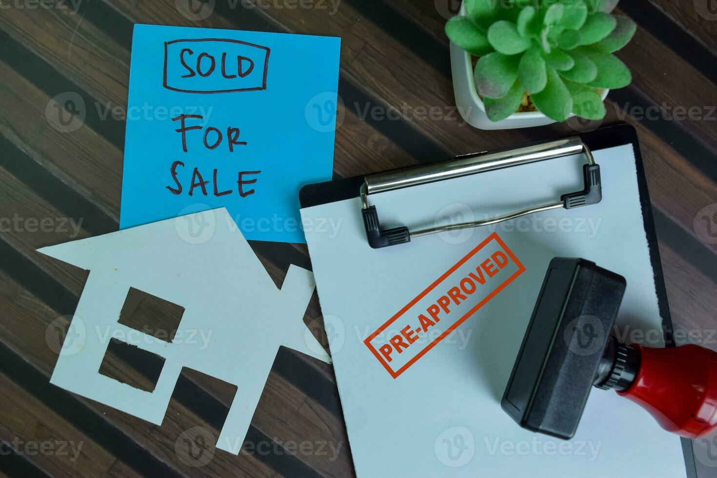 Red Handle Rubber Stamper Pre-Approved and Sold For Sale text isolated on wooden table. photo