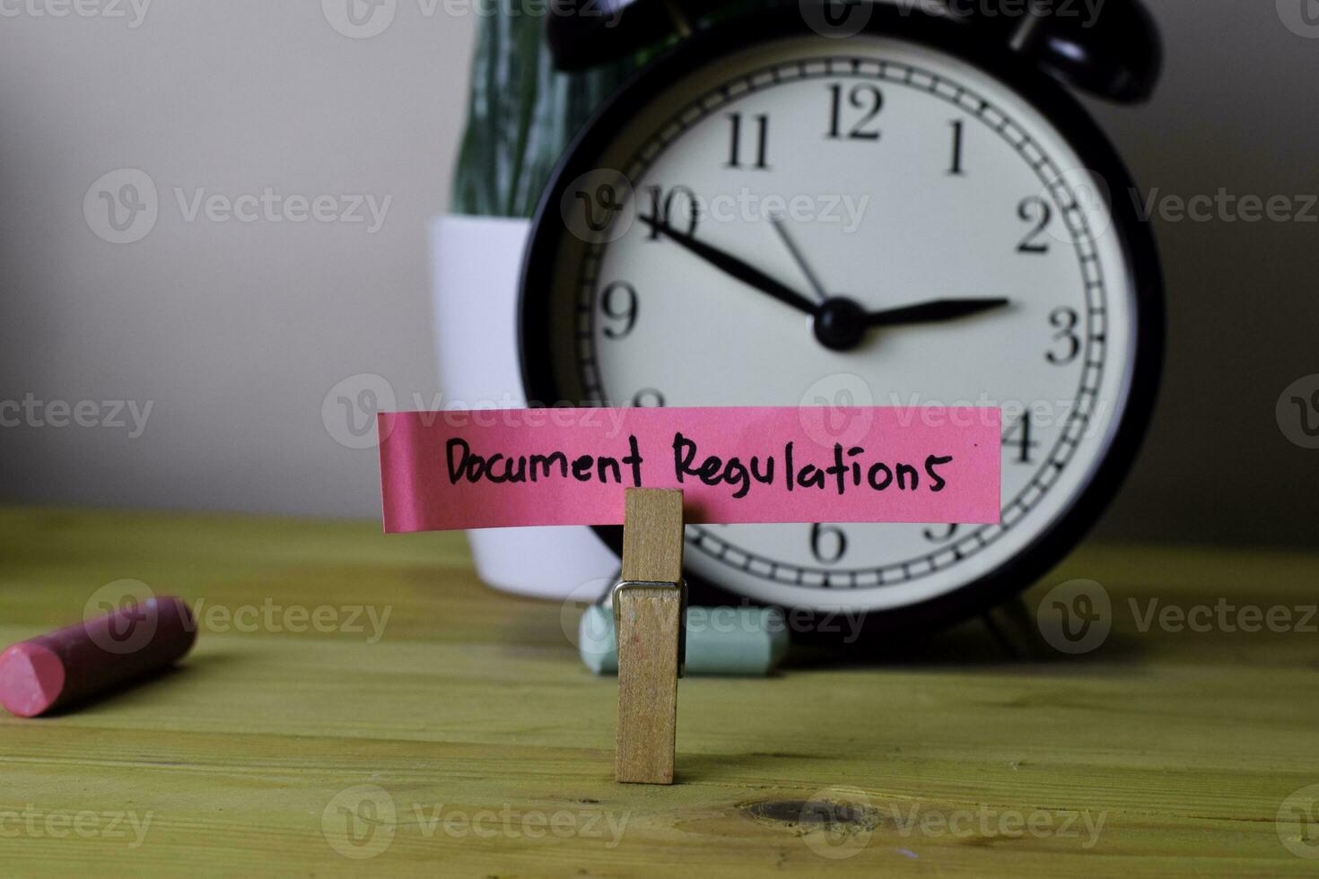 Document Regulations. Handwriting on sticky notes in clothes pegs on wooden office desk photo