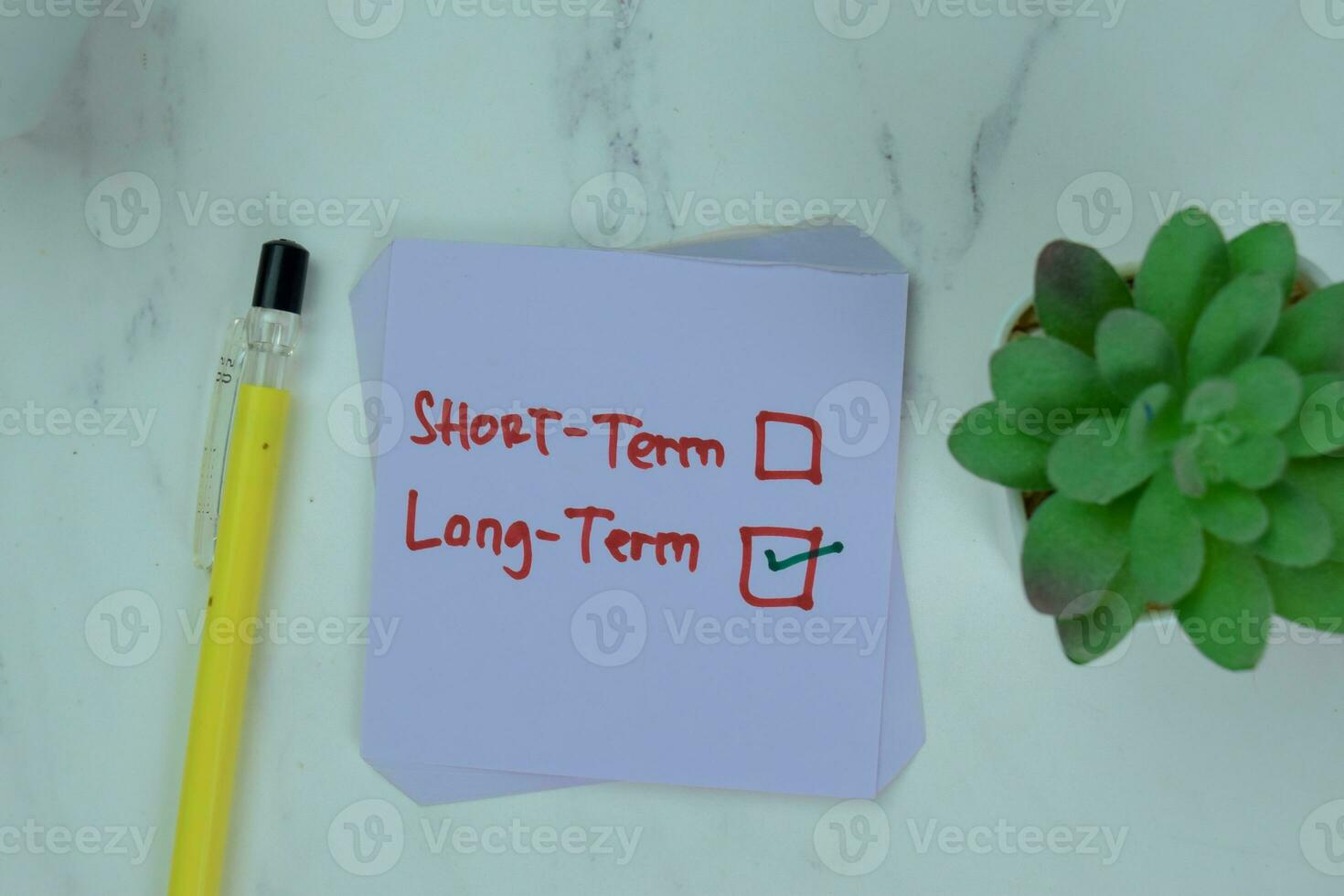 Concept of Long-Term write on a book isolated on Wooden Table. photo