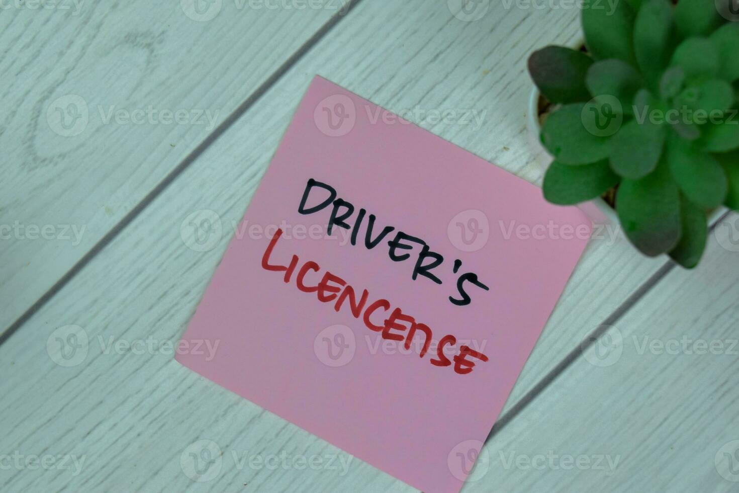 Concept of Driver's License write on sticky notes isolated on Wooden Table. photo