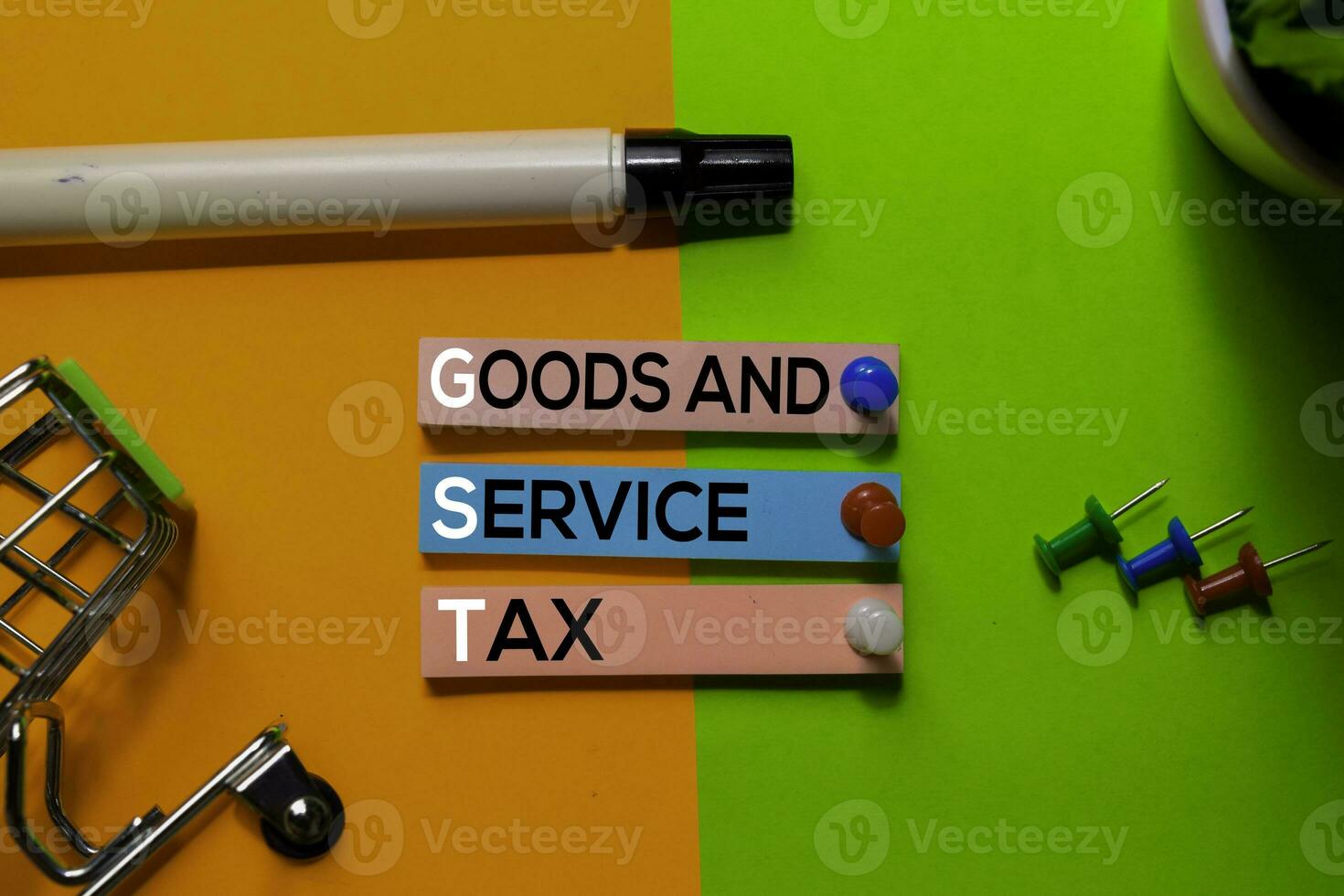 GST. Goods and Service Tax acronym on sticky notes. Office desk background photo