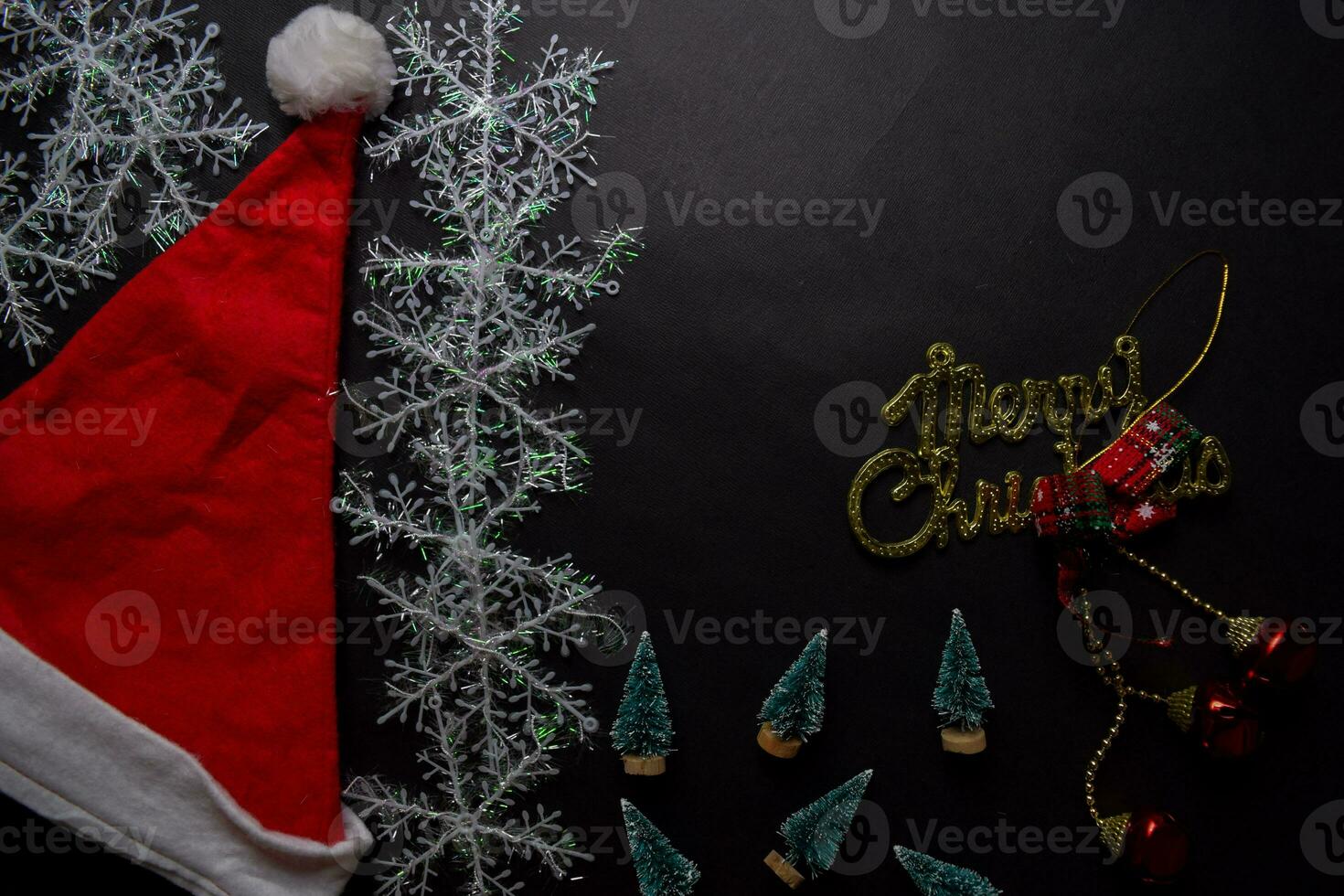 Santa Claus red hat, merry christmas text and Decorative Christmas gifts isolated on black background photo