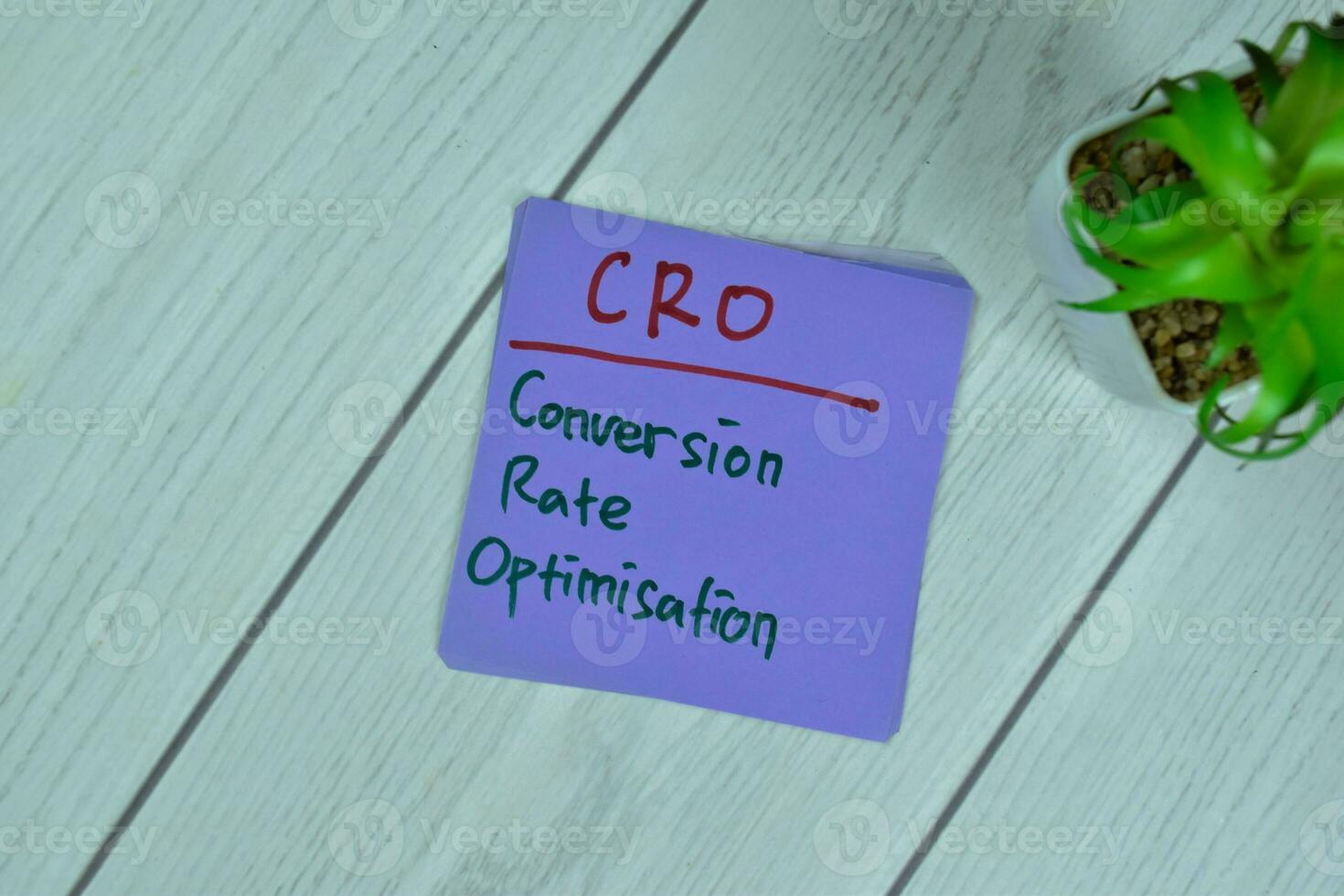 Concept of CRO - Conversion Rate Optimisation write on sticky notes isolated on Wooden Table. photo