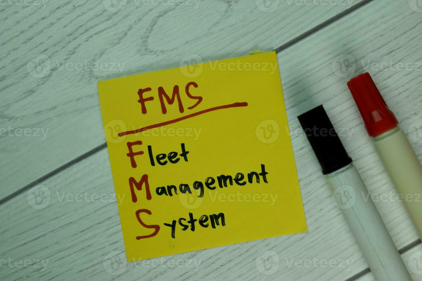 FMS - Fleet Management System write on sticky notes isolated on Wooden Table. photo