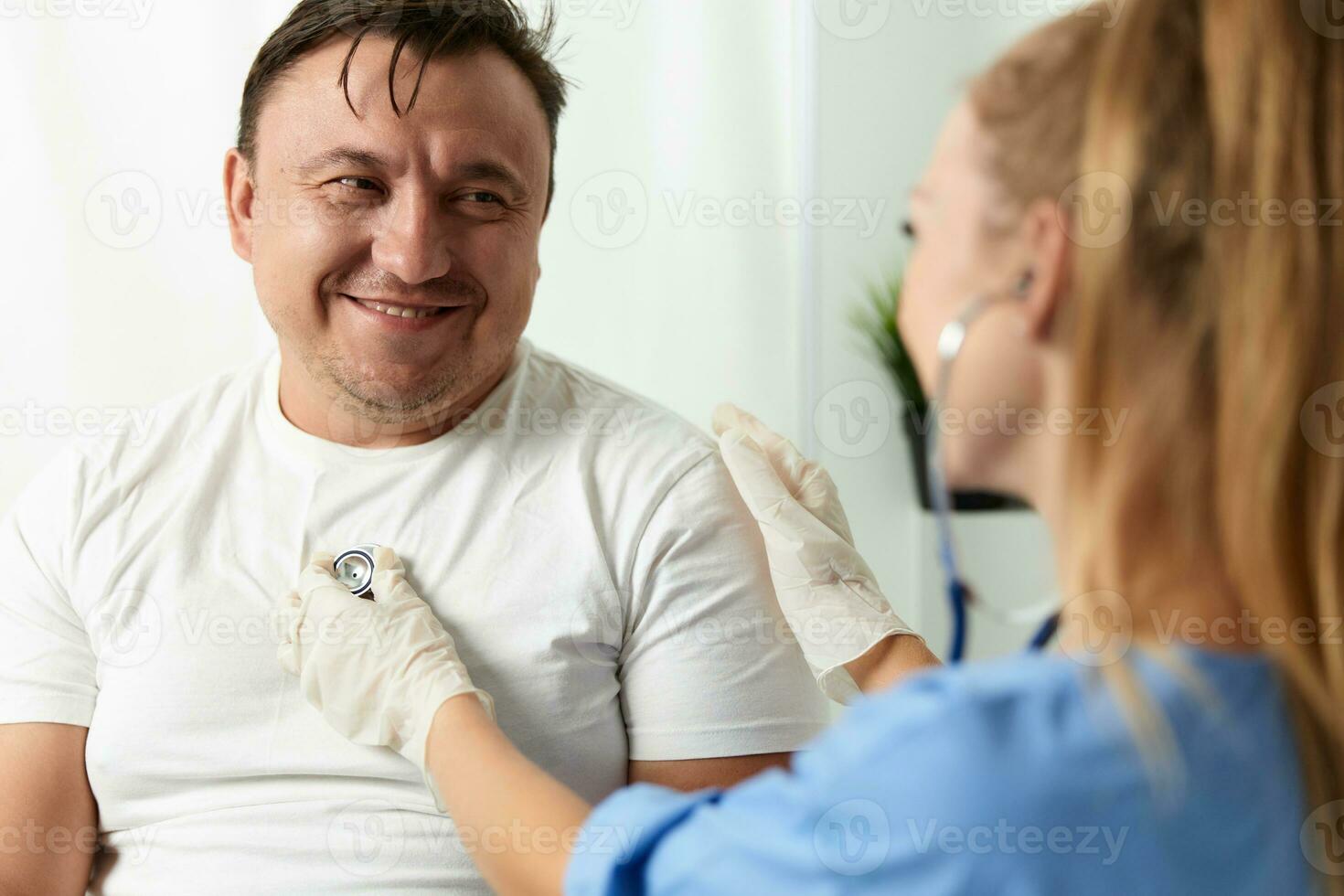 cheerful male patient next to female doctor checkup hospital photo
