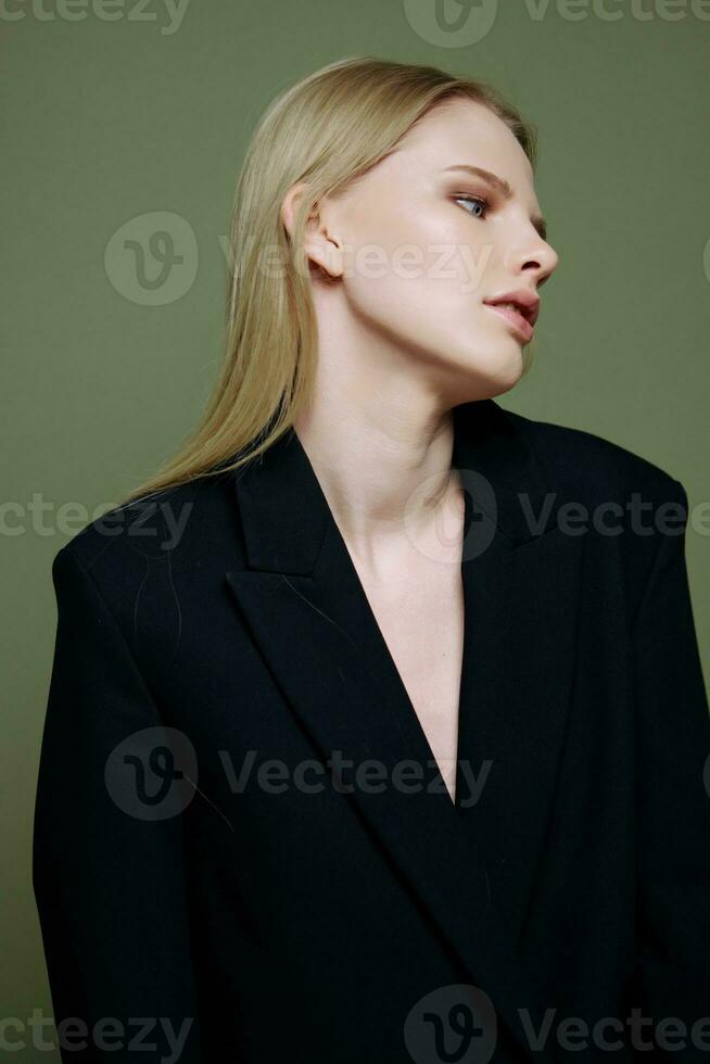 Stylish fashionable charming girl posing in profile looking to the side on a green olive background in the studio. Cool banner for brands photo