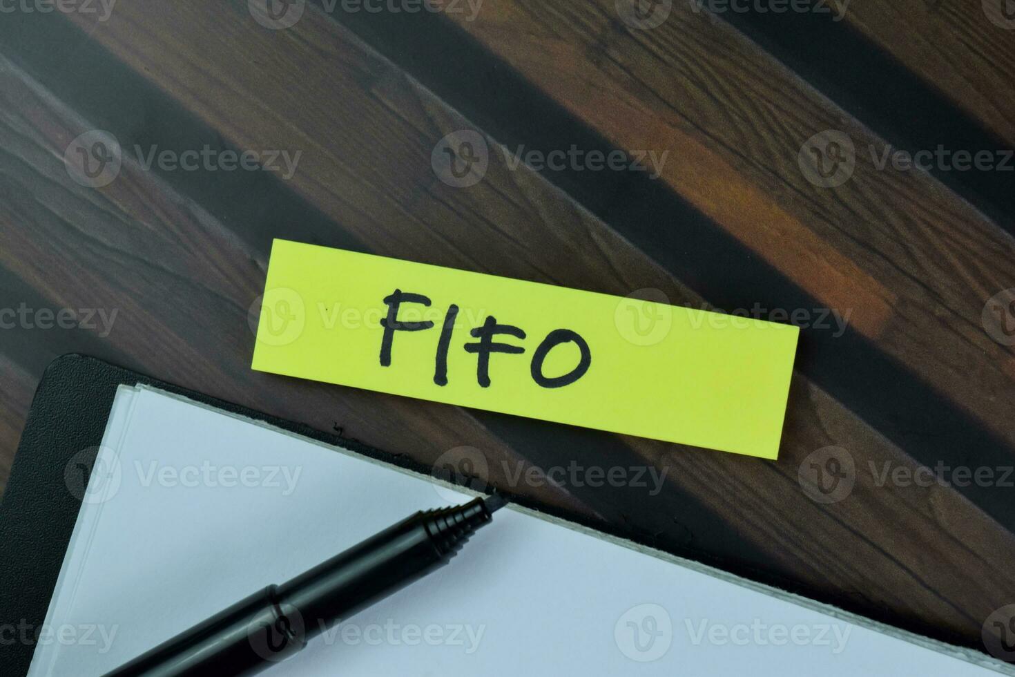 FIFO write on sticky notes isolated on Wooden Table. photo
