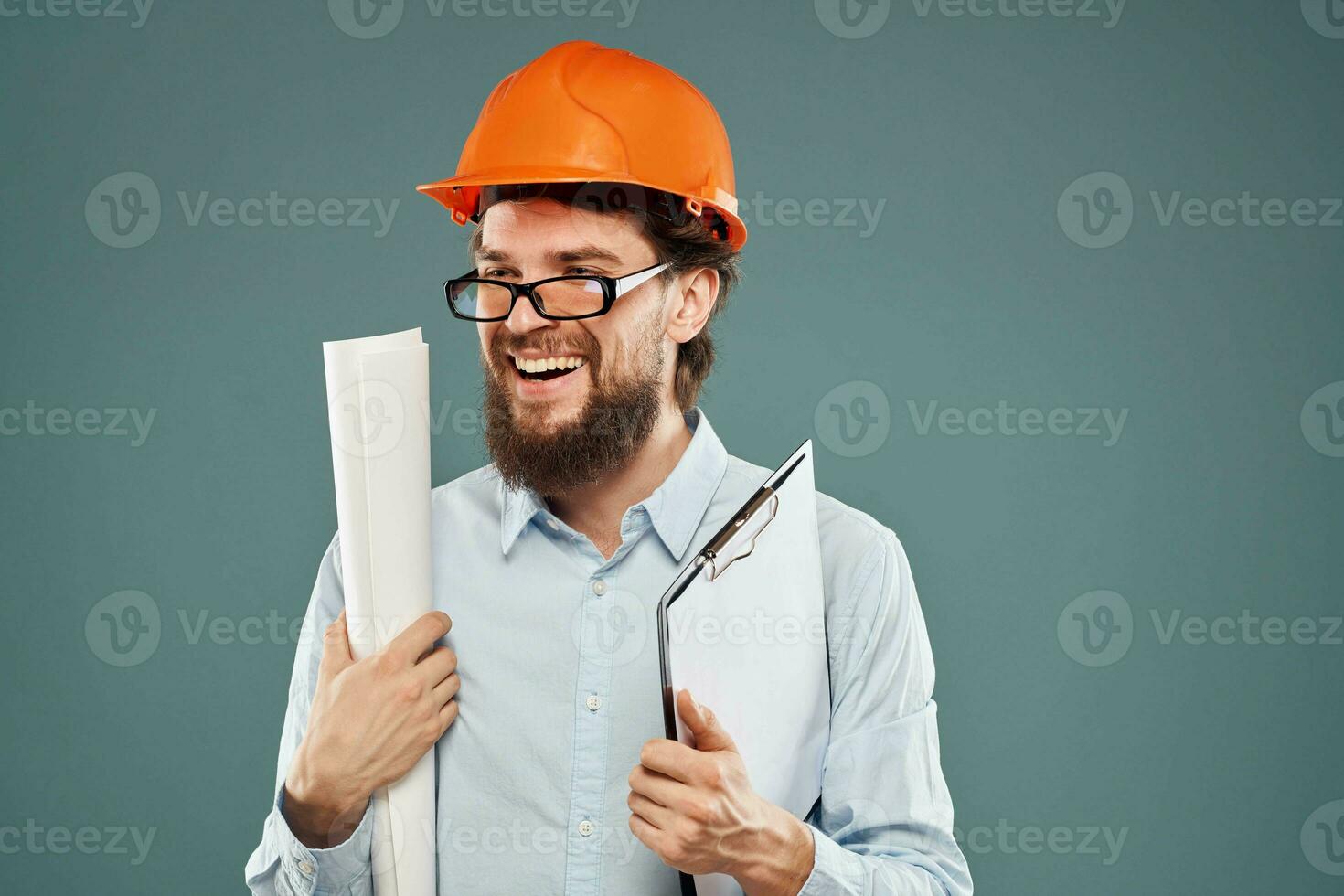 Cropped view of cheerful bearded man in orange paint in glasses with documents in hands photo