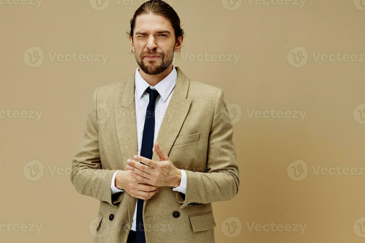 hermoso hombre emocional hombre en traje gesto con manos beige antecedentes foto