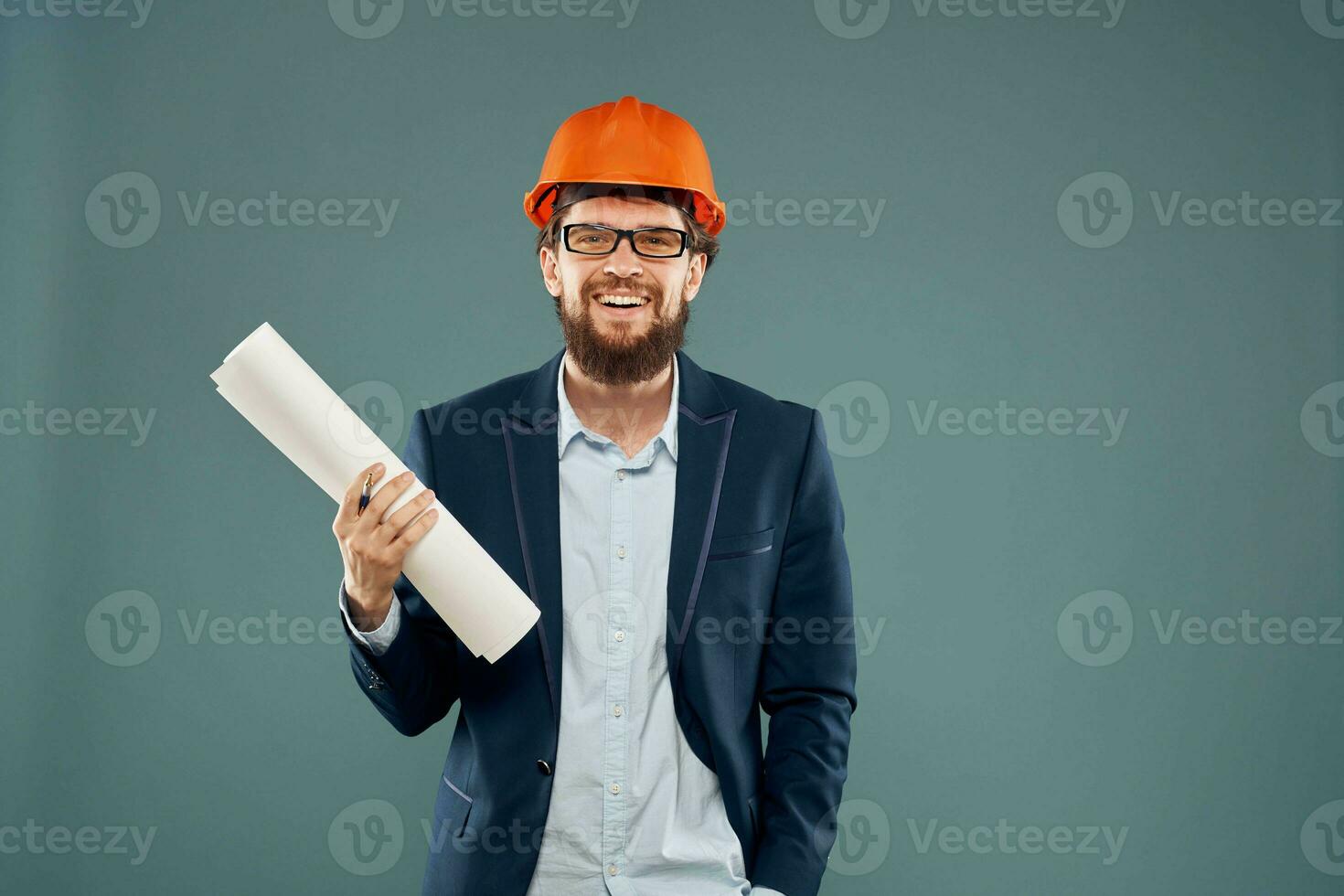 A man in a suit in an orange hard hat blueprints in the hands of a construction engineer photo