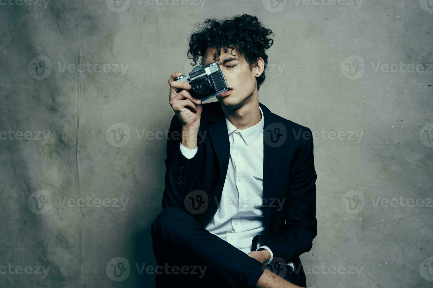 guy in a classic suit with a camera on a fabric background hobby photo