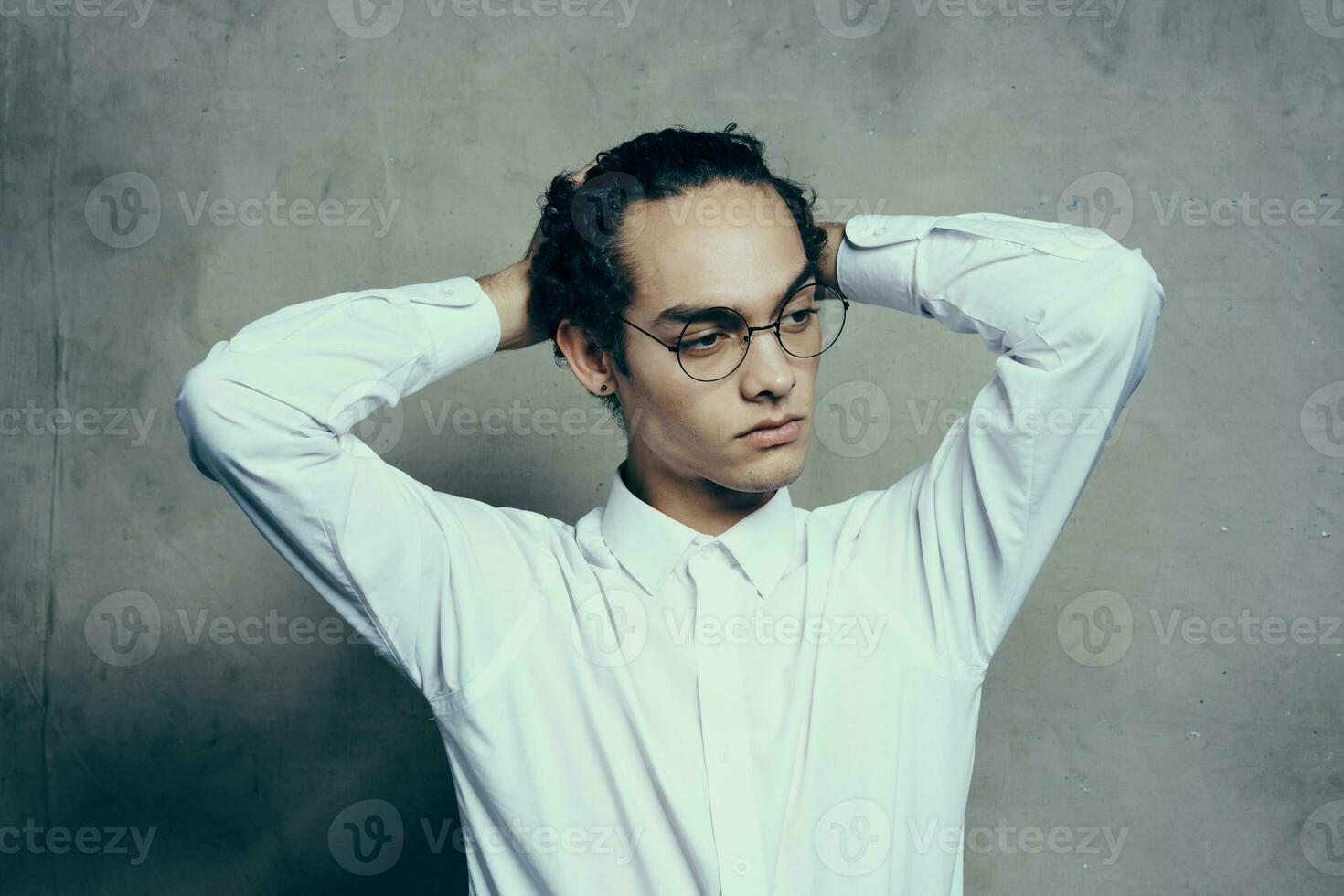 attractive young man wearing glasses white shirt straightens hair on his head portrait photo