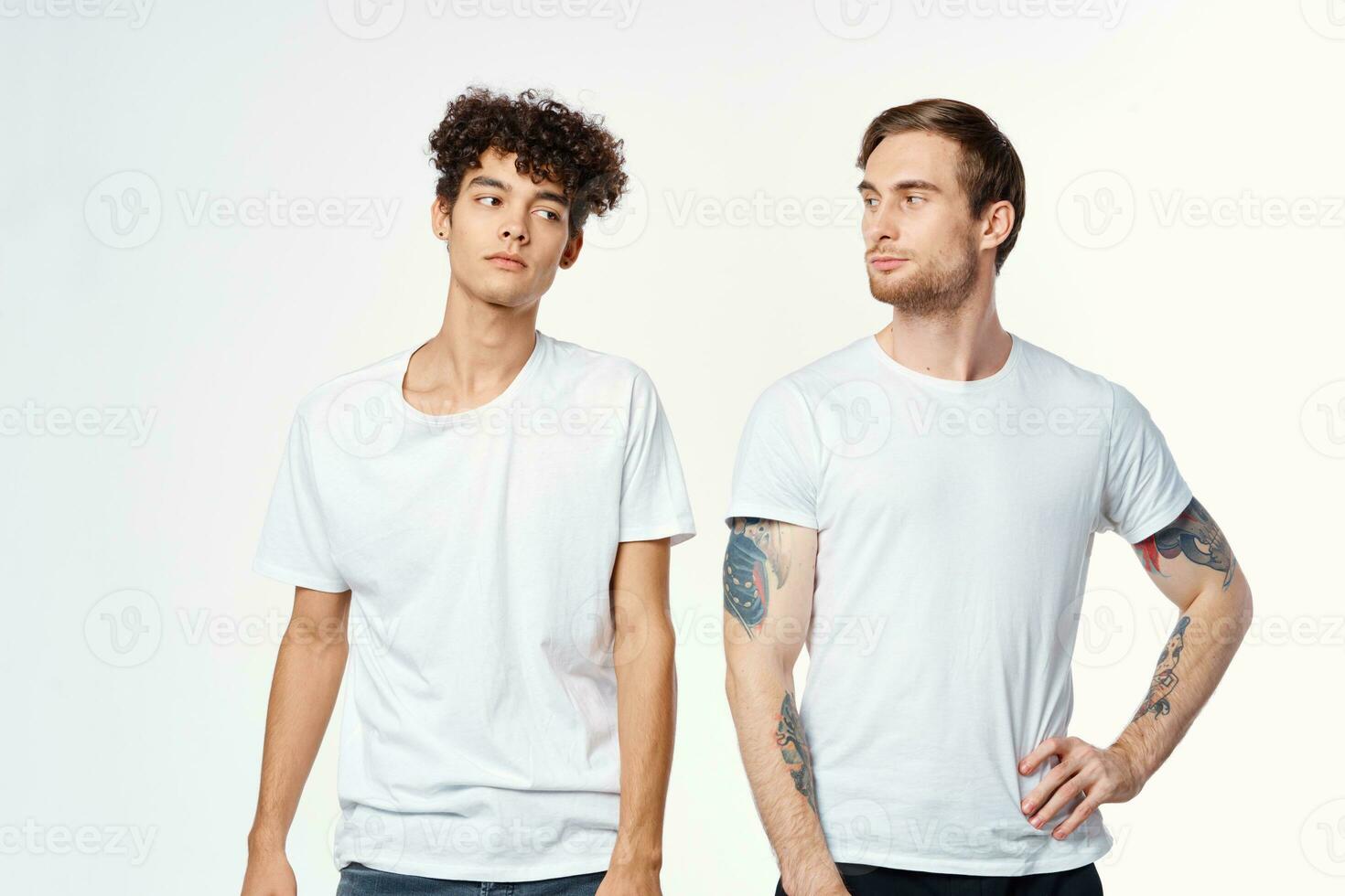 two men in white t-shirts stand side by side cropped view studio photo