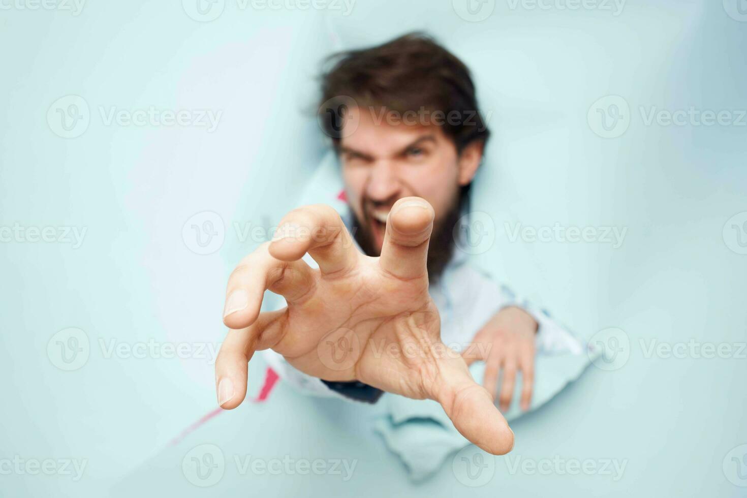 Emotional man stretches his hand forward looking through the wall of emotions office photo