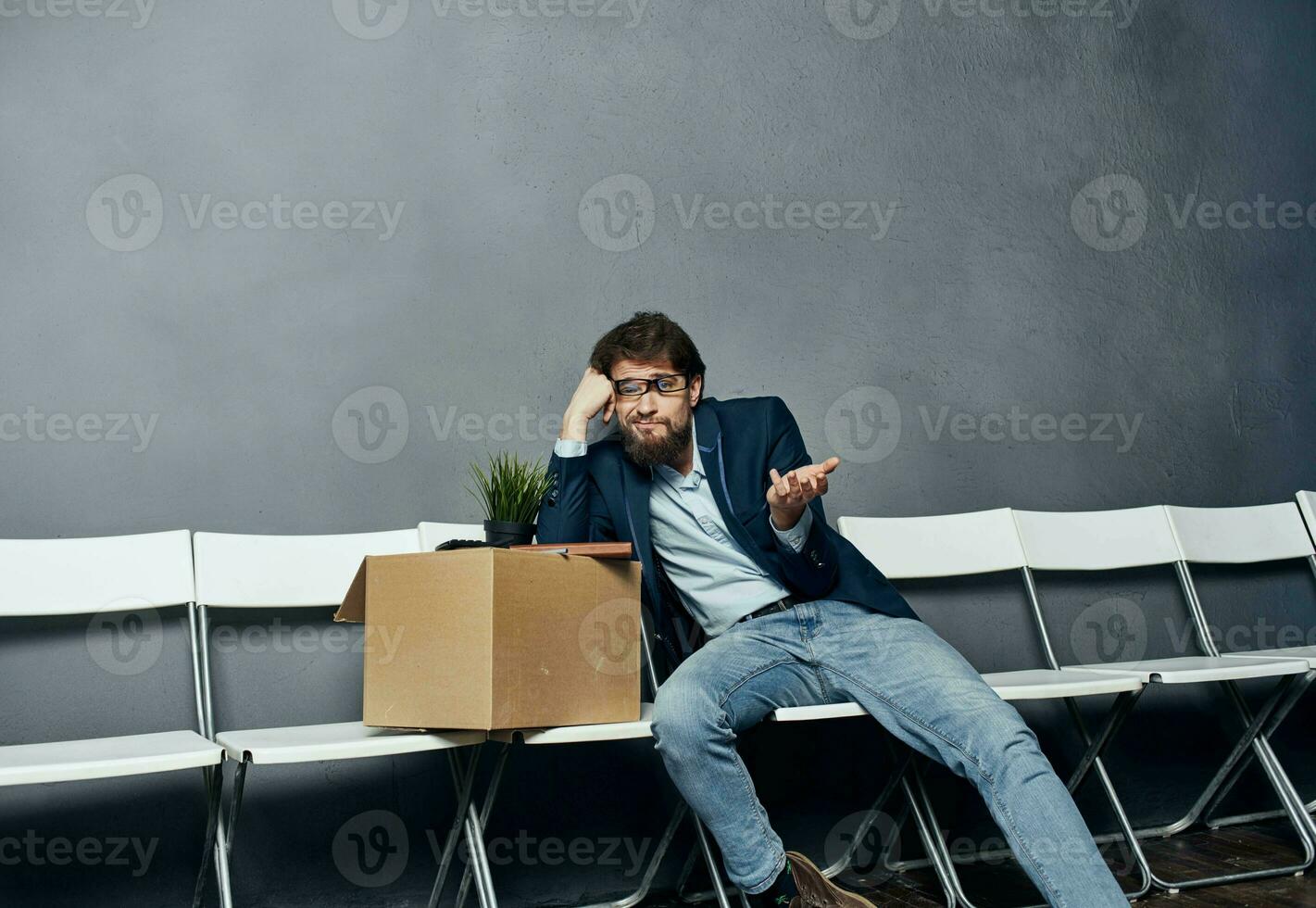 Man sits on a chair box with things dismissing discontent depression photo