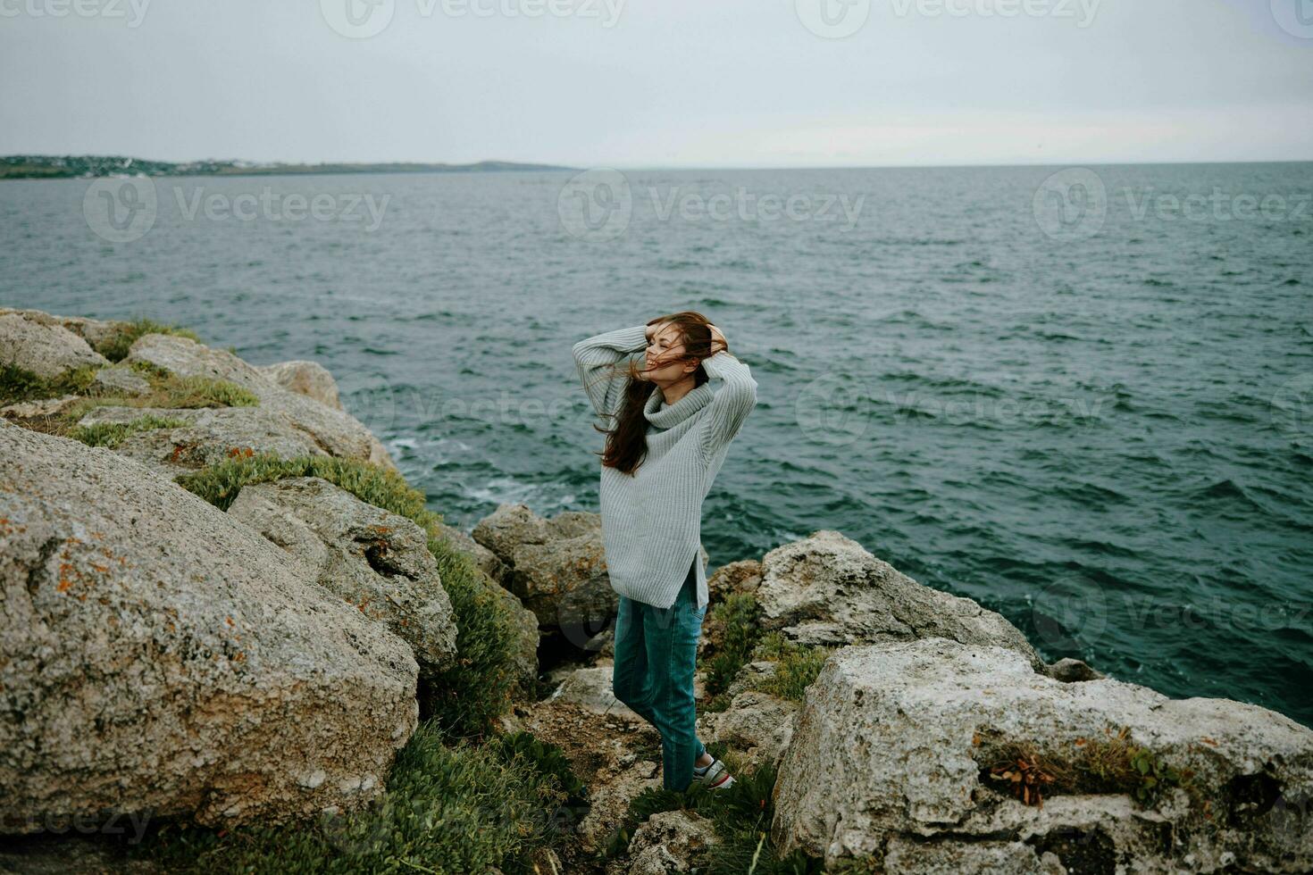 woman long hair nature rocks coast landscape female relaxing photo