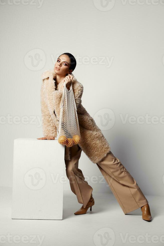 pretty woman with bright makeup beige coat mesh with oranges Studio photo