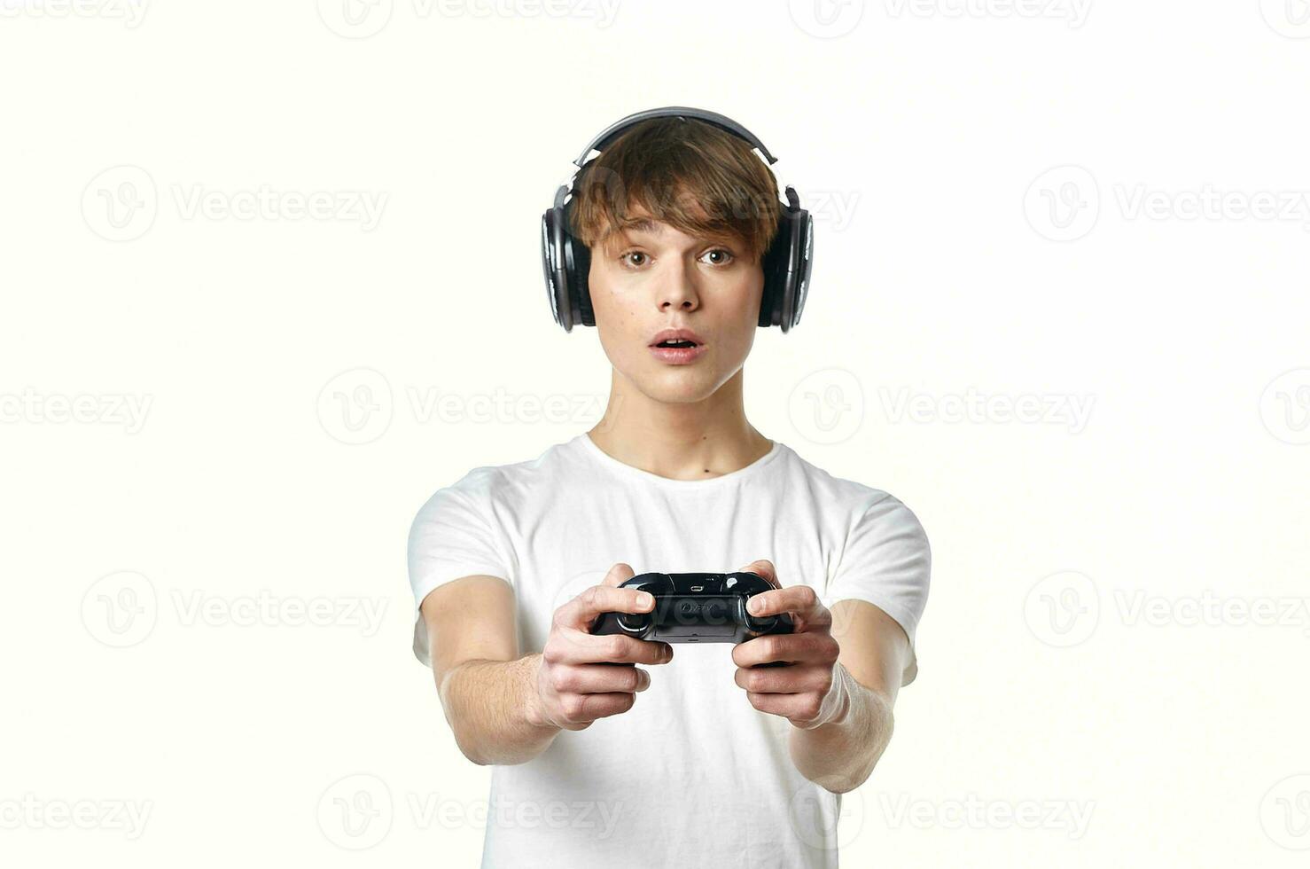 chico en un blanco camiseta en auriculares con un palanca de mando vídeo juegos tecnología jugador foto