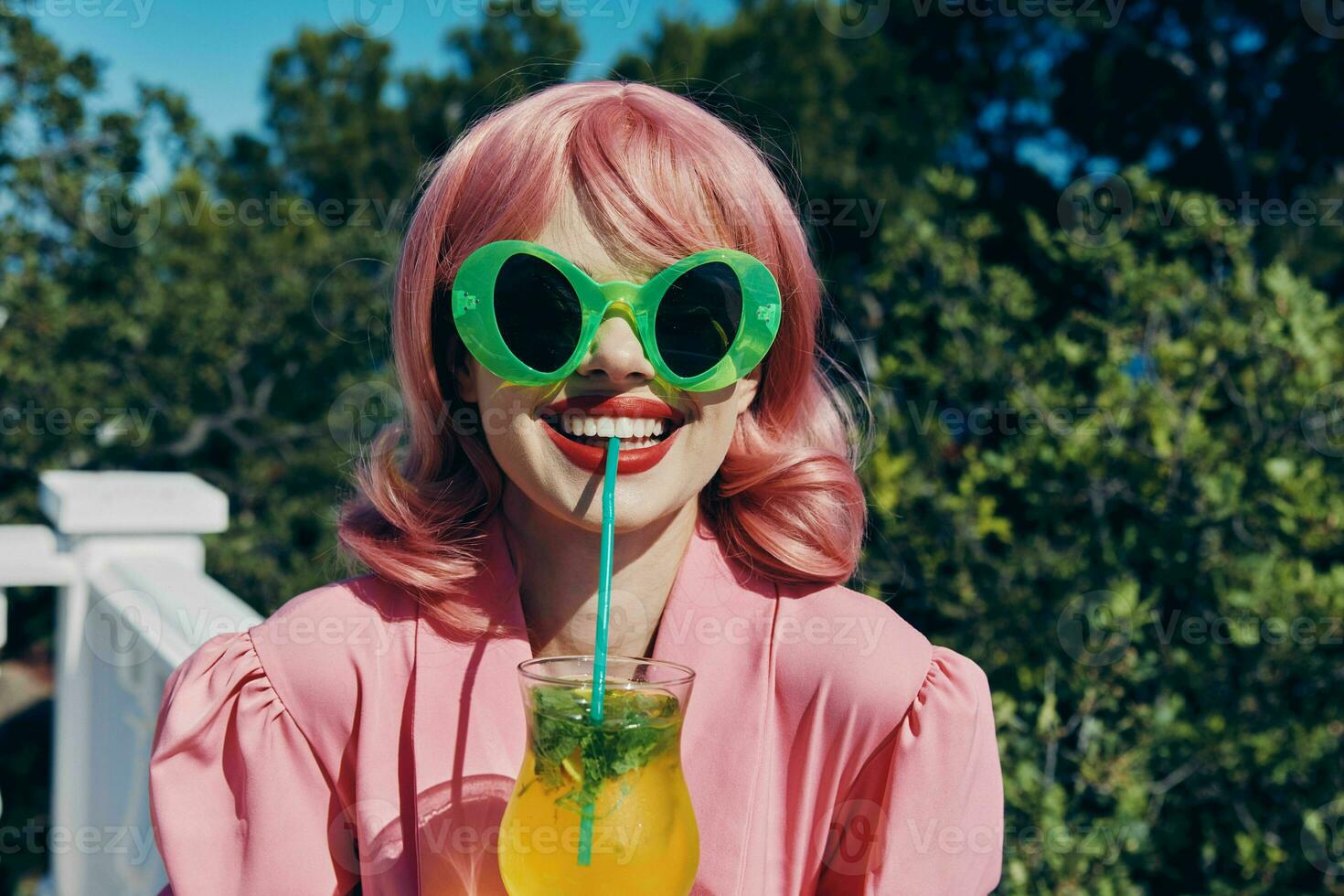 Young female enjoying a colorful cocktail hotel terrace Happy female relaxing photo