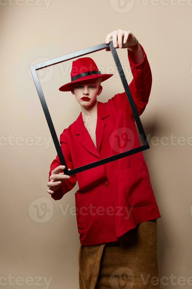 retrato de un mujer marco en mano en rojo sombrero y chaqueta aislado antecedentes foto