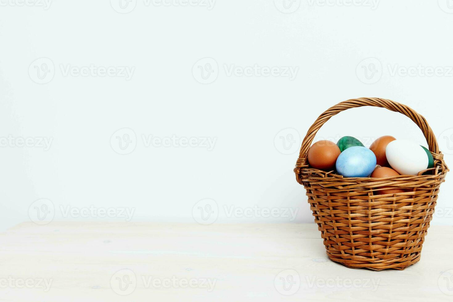 Easter eggs in a wicker basket on a Light background Copy Space photo