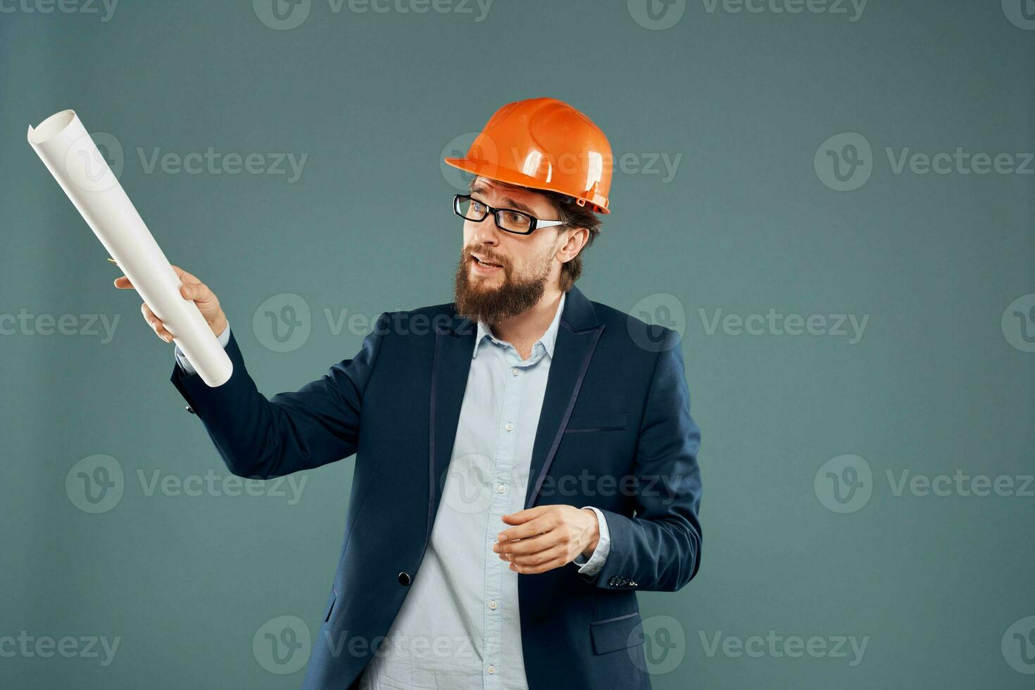 A man in a suit in an orange hard hat blueprints in the hands of a construction engineer photo