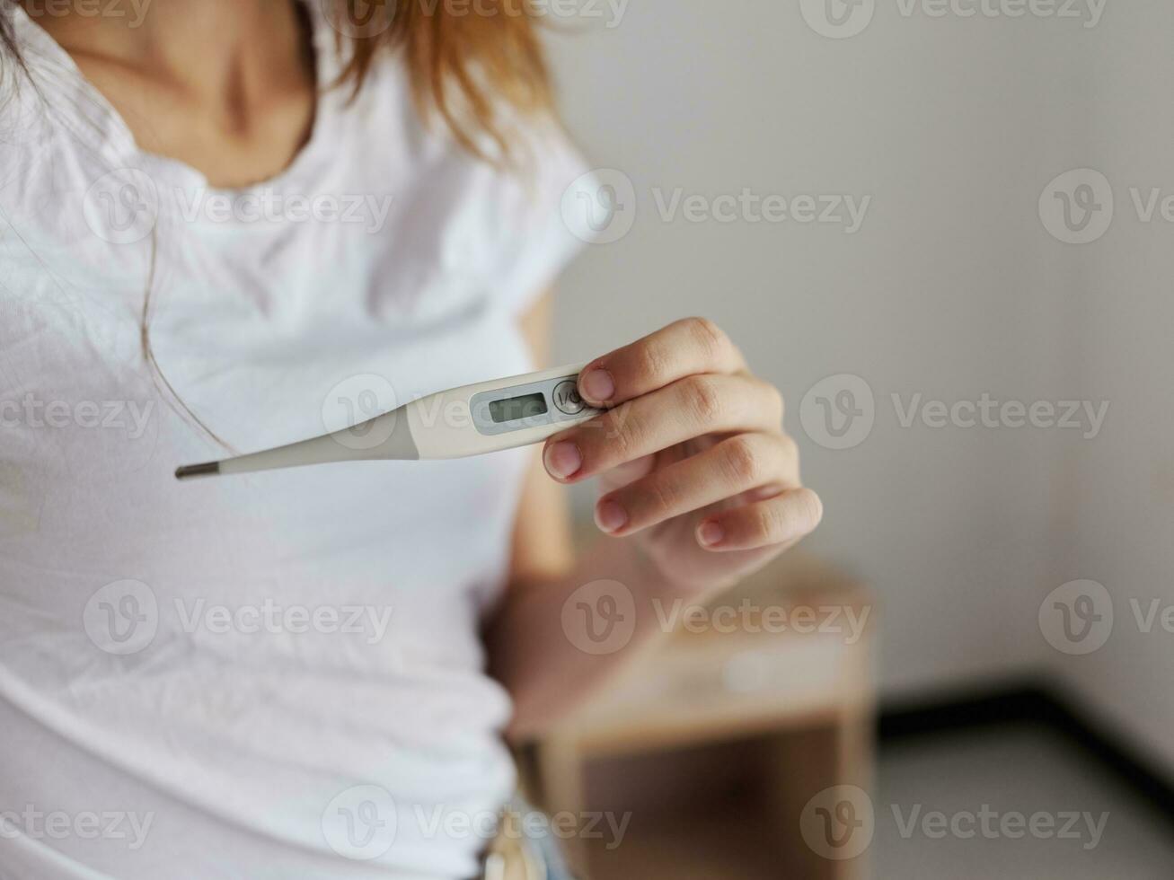 mujer participación un termómetro en su mano temperatura salud cheque foto