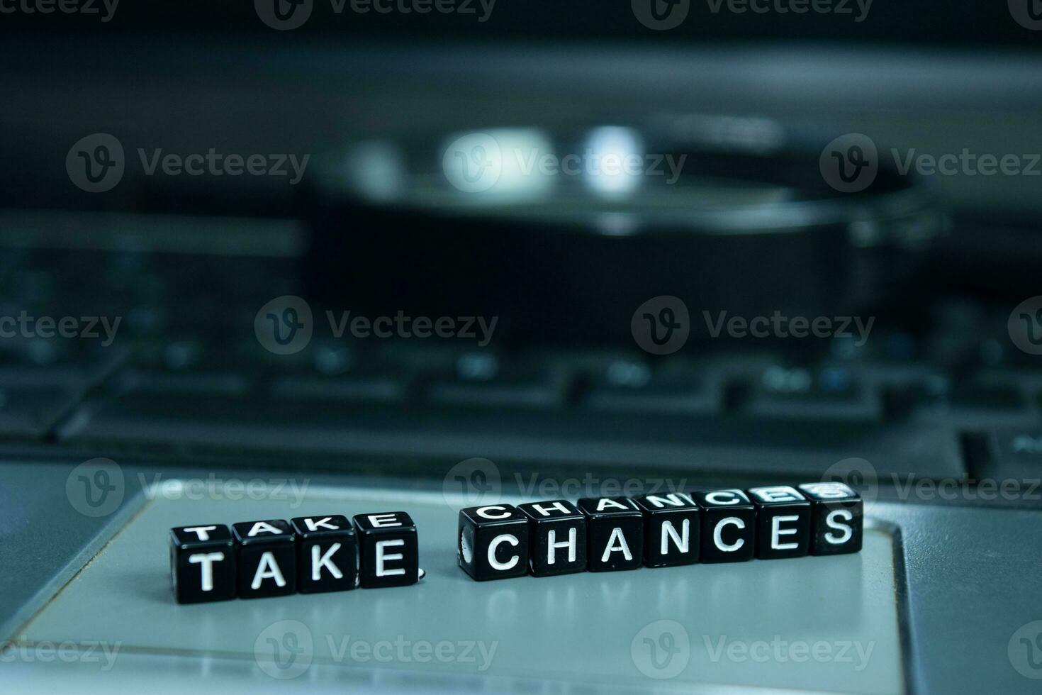Take Chances text wooden blocks in laptop background. Business and technology concept photo