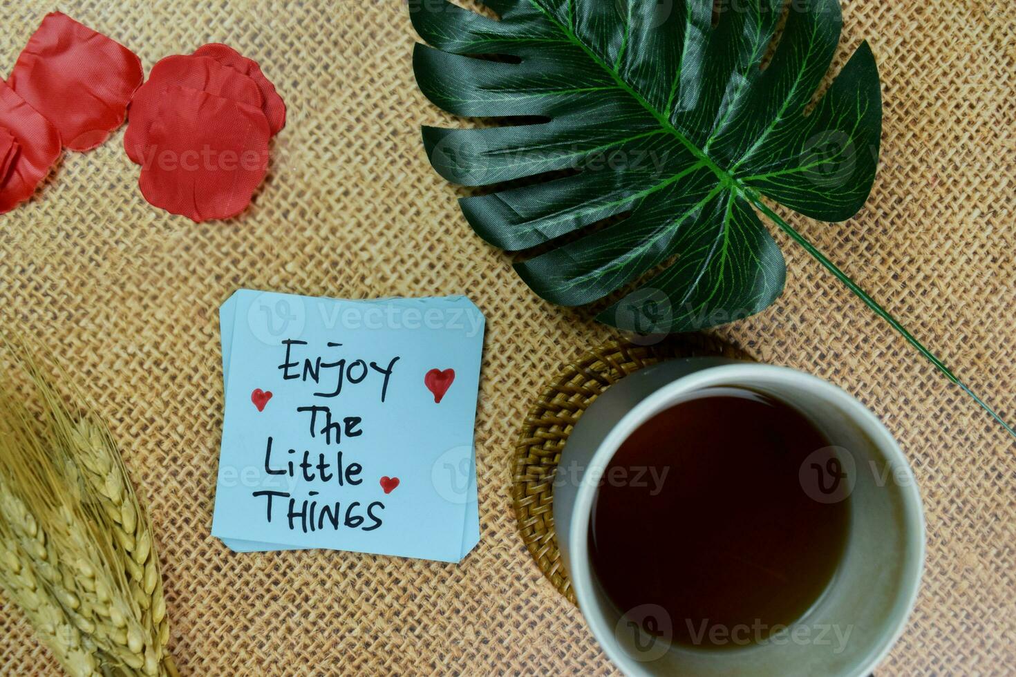 Enjoy The Little Things write on sticky notes isolated on Wooden Table. photo
