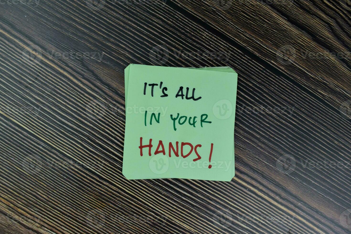 Concept of It's All In Your Hands write on sticky notes isolated on Wooden Table. photo