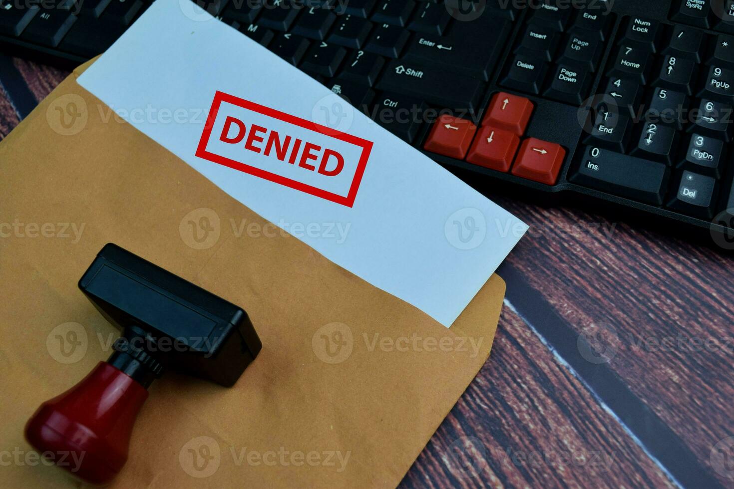 Red Handle Rubber Stamper and Denied text Isolated on wooden table background photo